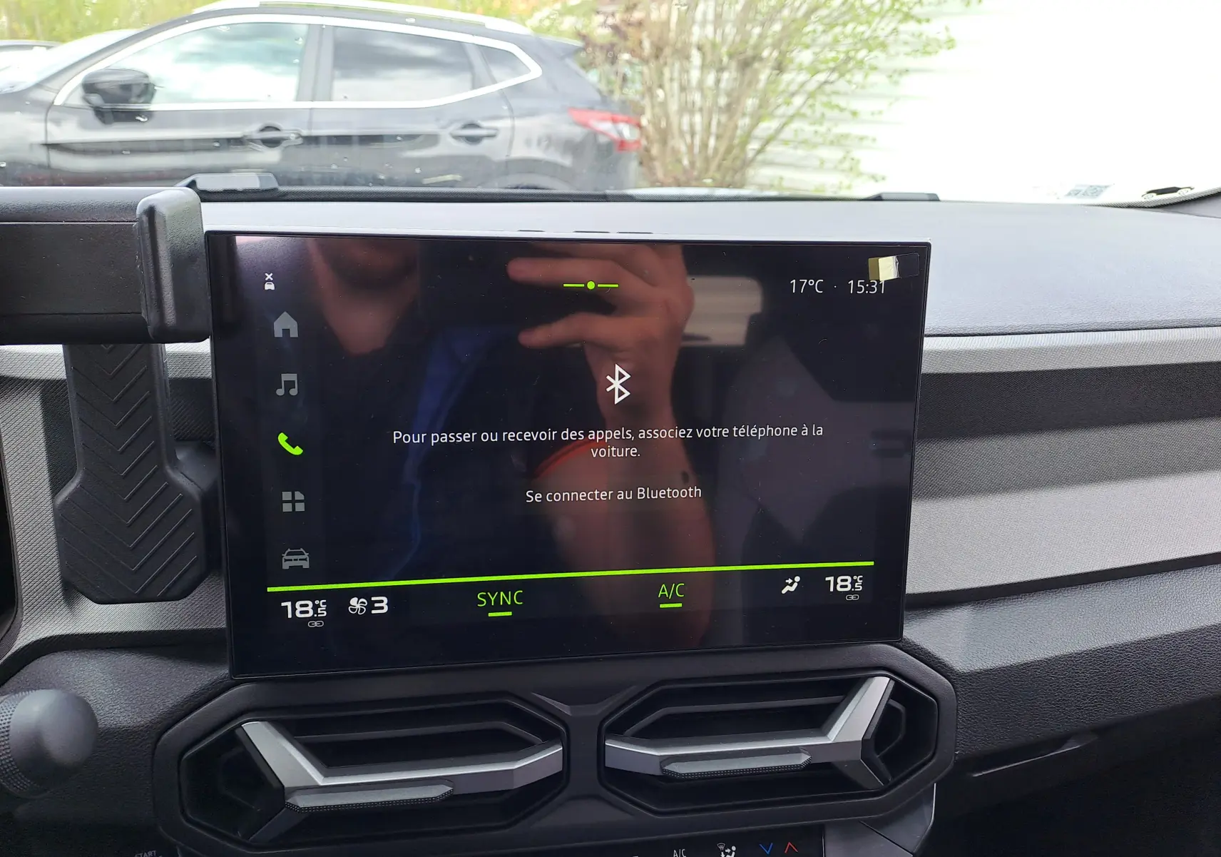 Écran tactile central du tableau de bord du Dacia Bigster vert cèdre, affichant la connexion Bluetooth et la climatisation.