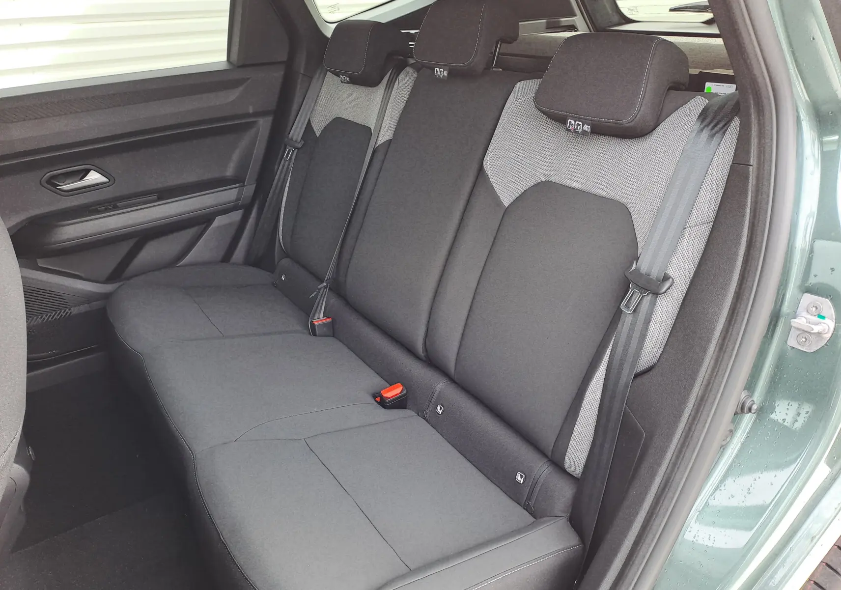Vue intérieure côté droit des sièges arrière gris foncé et clair du Dacia Bigster Hybrid 155 Journey + Pack Parking vert cèdre 2026.