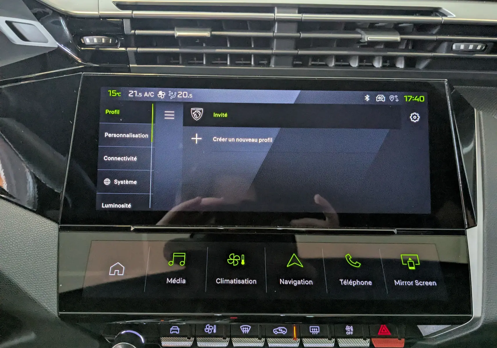 Écran tactile central de la Peugeot 408 Hybrid 145 GT 2025, affichant le menu profil, entouré de commandes tactiles et boutons argentés.