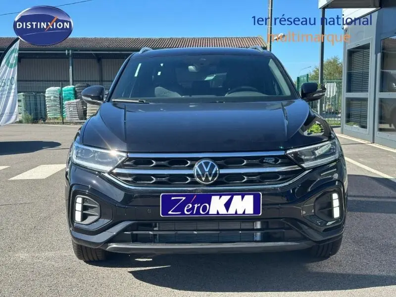 Vue avant d'un Volkswagen T-Roc 1.5 TSI Evo2 noir intense nacré avec calandre chromée et feux LED allumés.