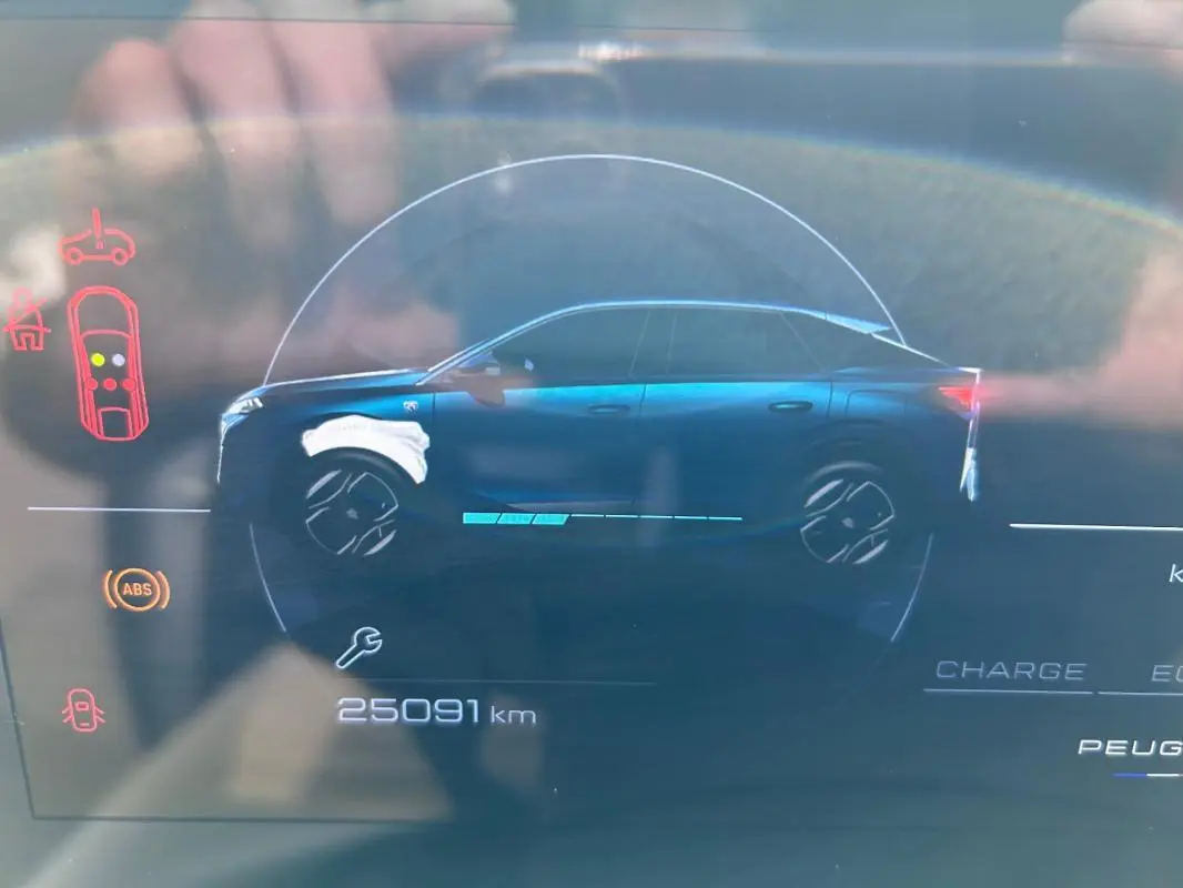 Affichage numérique du profil latéral droit bleu d’un Peugeot 3008 Hybrid 136 e-DCS6 GT avec indicateurs d’alerte et compteur kilométrique.