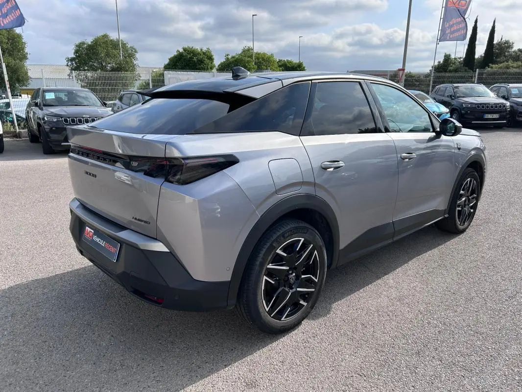 Peugeot 3008 Hybrid gris clair vue 3/4 arrière droit, avec jantes alliage noires et toit ouvrant.