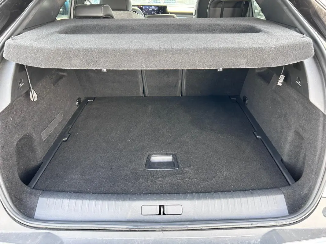 Coffre ouvert vu de l'arrière du Peugeot 3008 gris clair, montrant un espace de chargement propre et couvert.