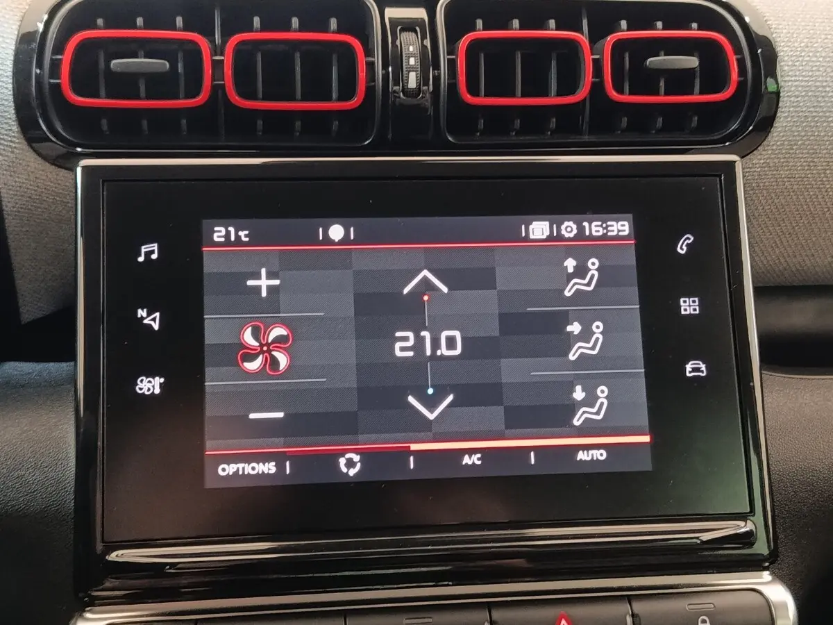 Écran tactile central et quatre aérateurs noirs avec contours rouges dans l’habitacle d’une Citroën C3 Aircross beige.