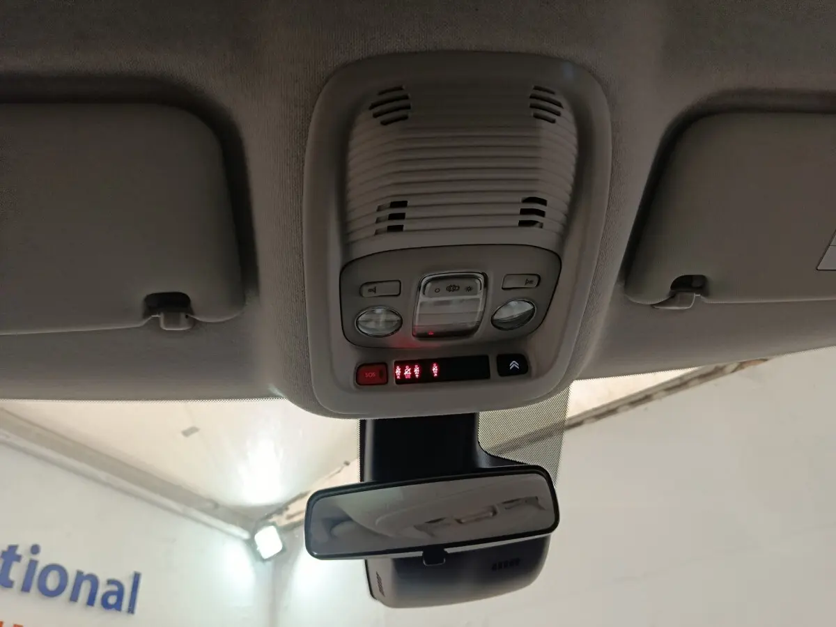 Vue intérieure du plafonnier et rétroviseur central d’un Citroën C3 Aircross beige, avec commandes d’éclairage et bouton SOS.