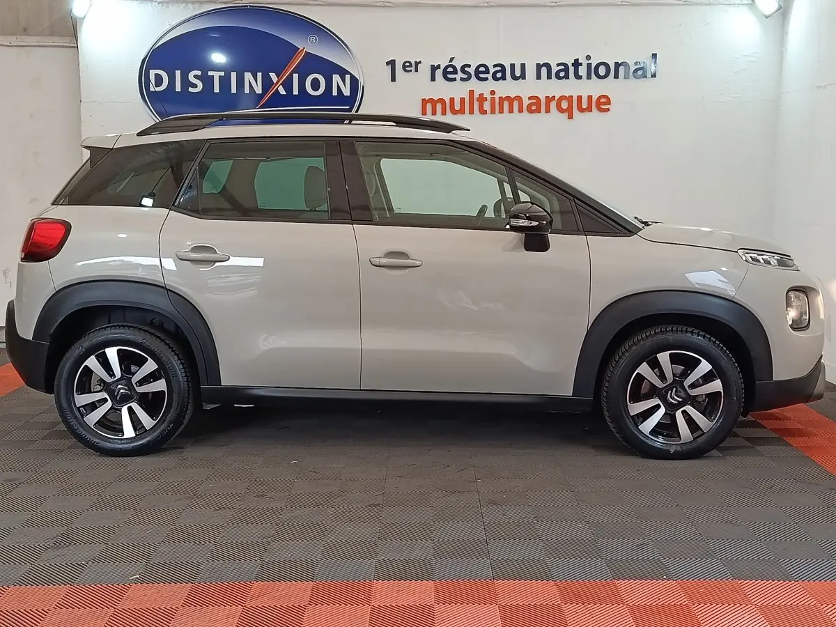 Profil latéral droit d'une Citroën C3 Aircross beige 2021 avec toit noir et jantes alliage bicolores.