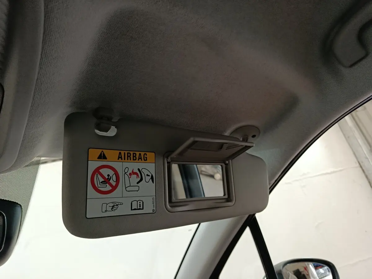 Détail du pare-soleil côté conducteur avec miroir intégré et avertissement airbag dans une Citroën C3 Aircross beige.