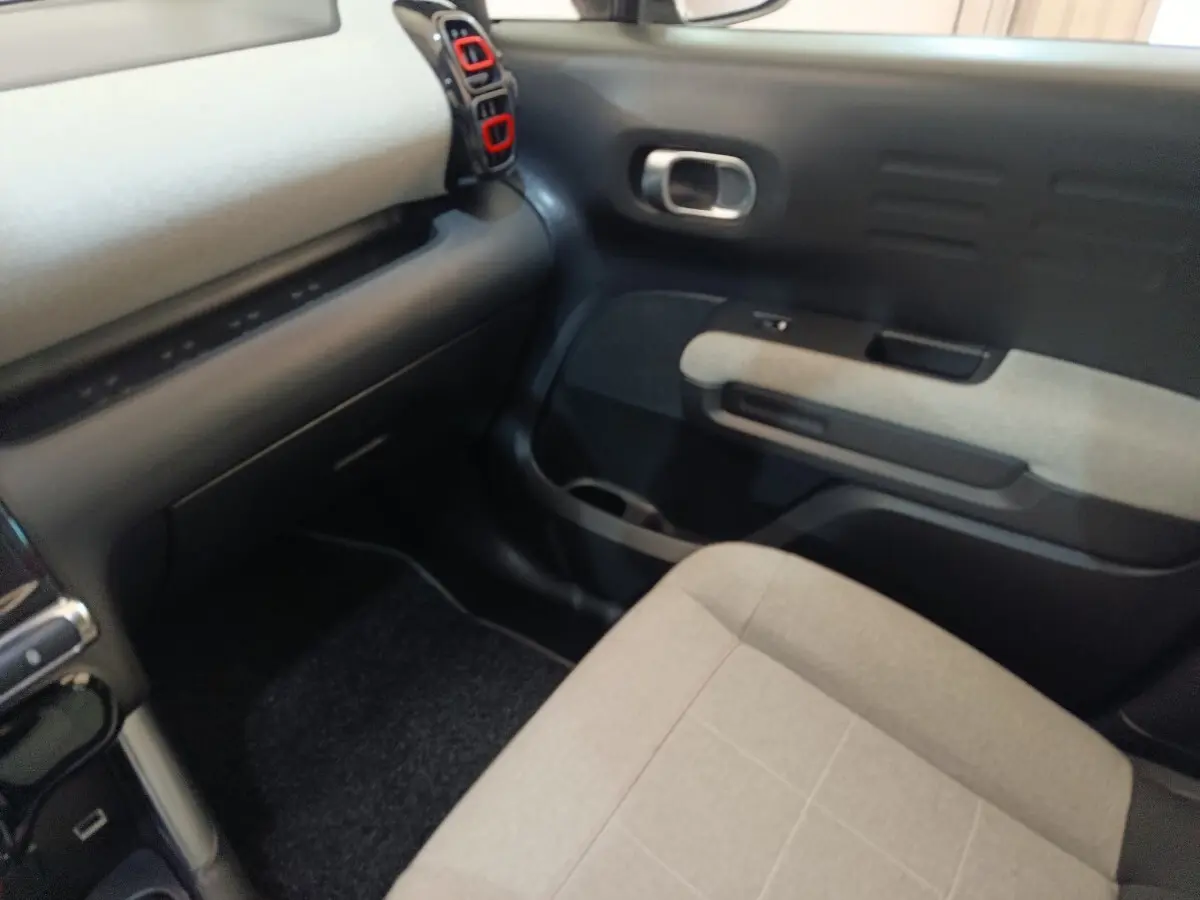 Vue intérieure côté passager avant du Citroën C3 Aircross beige, avec tableau de bord et garnitures grises.