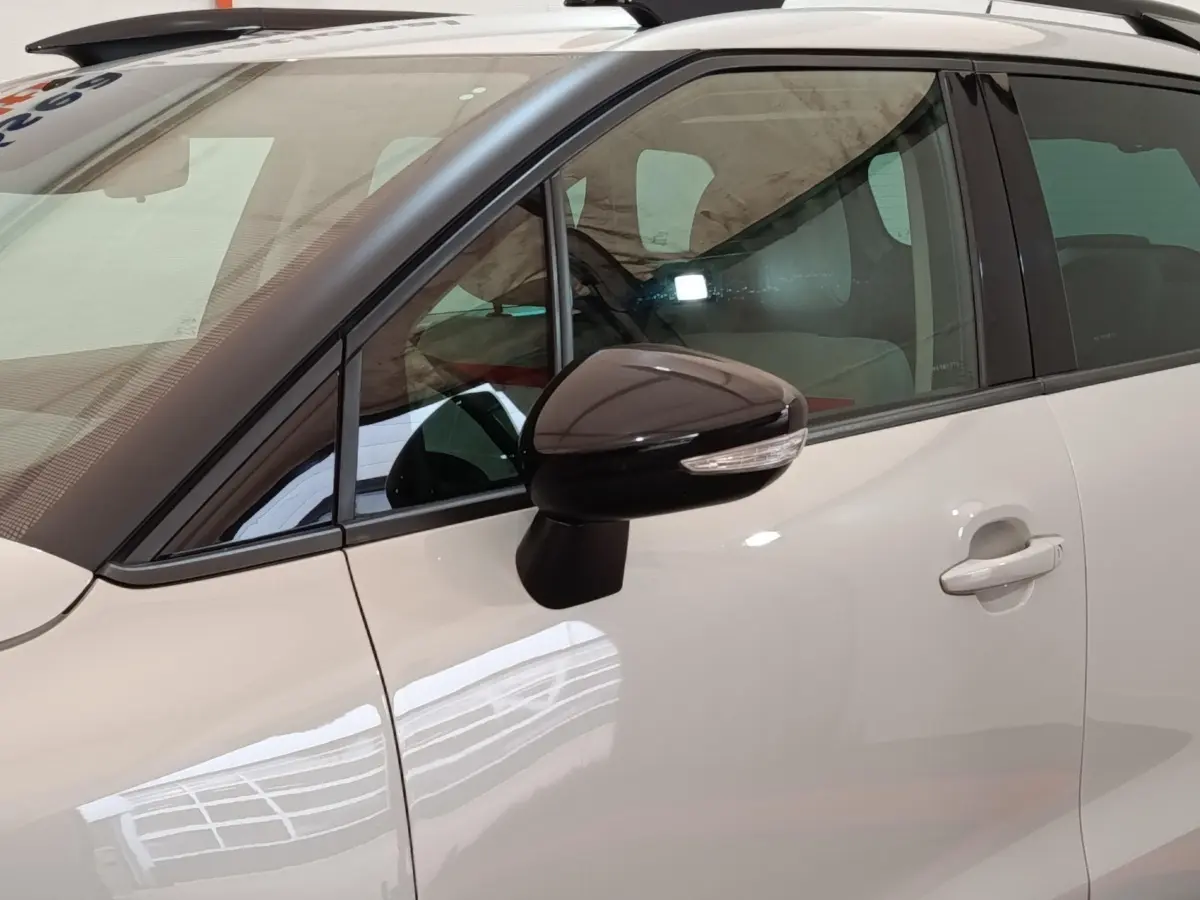 Vue latérale côté gauche d'une Citroën C3 Aircross beige avec rétroviseur noir et toit blanc.