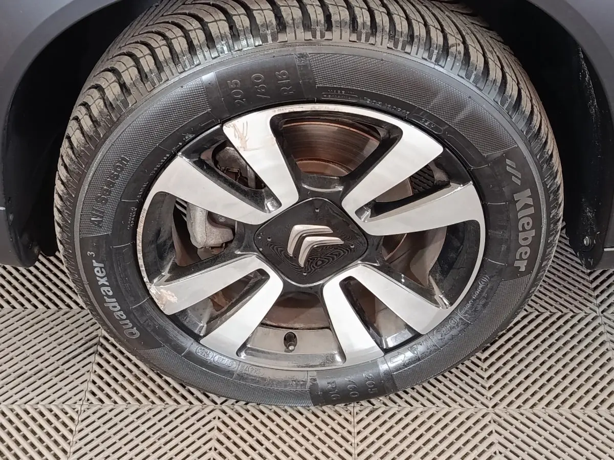 Gros plan sur la roue avant droite d'un Citroën C3 Aircross beige, avec jante alliage et logo Citroën central.