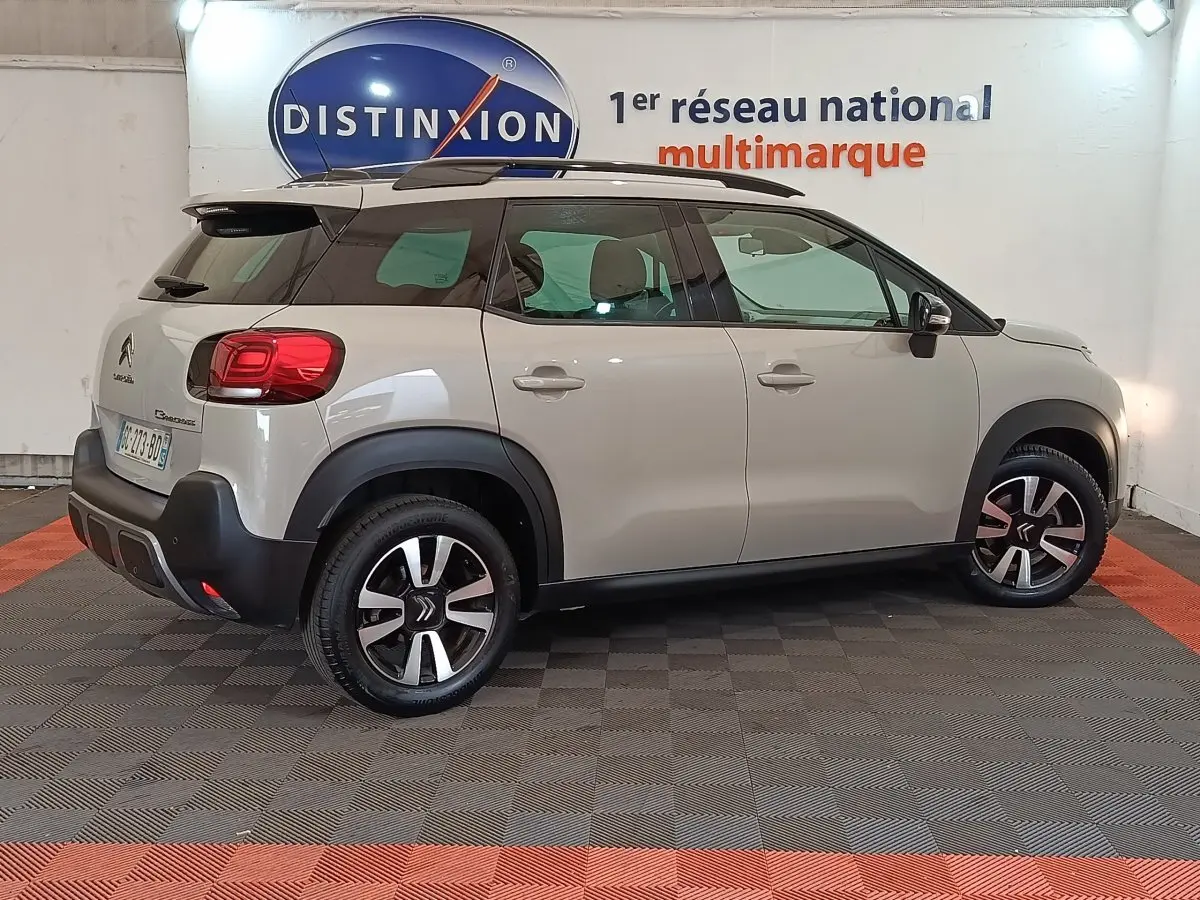 Vue de profil droit d'un Citroën C3 Aircross beige 2021 avec toit noir et jantes alliage distinctives.