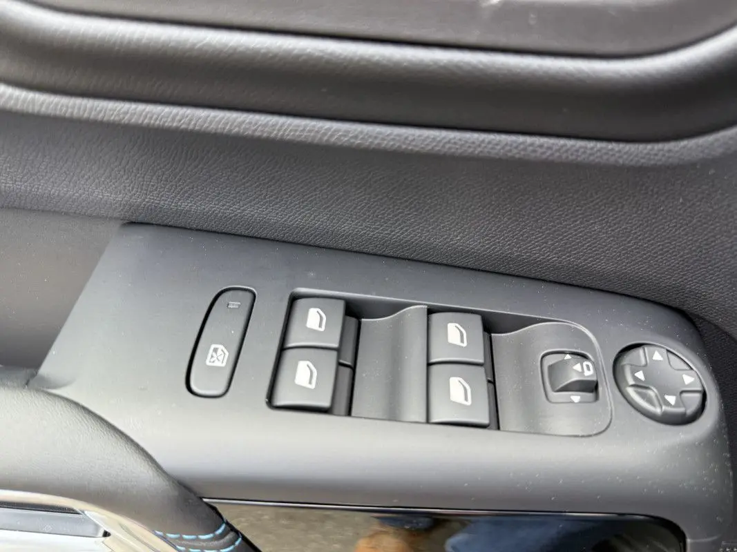 Gros plan sur les commandes de lève-vitres et rétroviseurs côté conducteur du Citroën C5 Aircross gris platinium 2025.