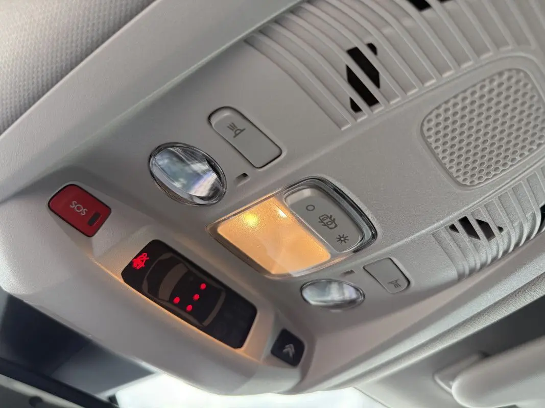 Vue en gros plan du plafonnier gris platinium du Citroën C5 Aircross 2025 avec éclairage intérieur et bouton SOS rouge.
