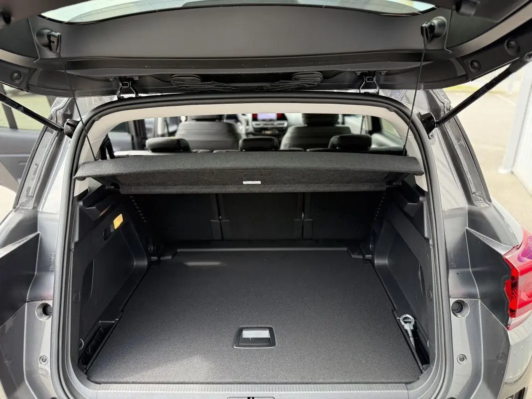 Coffre ouvert vu de l’arrière d’un Citroën C5 Aircross gris platinium métal, montrant un espace de chargement spacieux et propre.