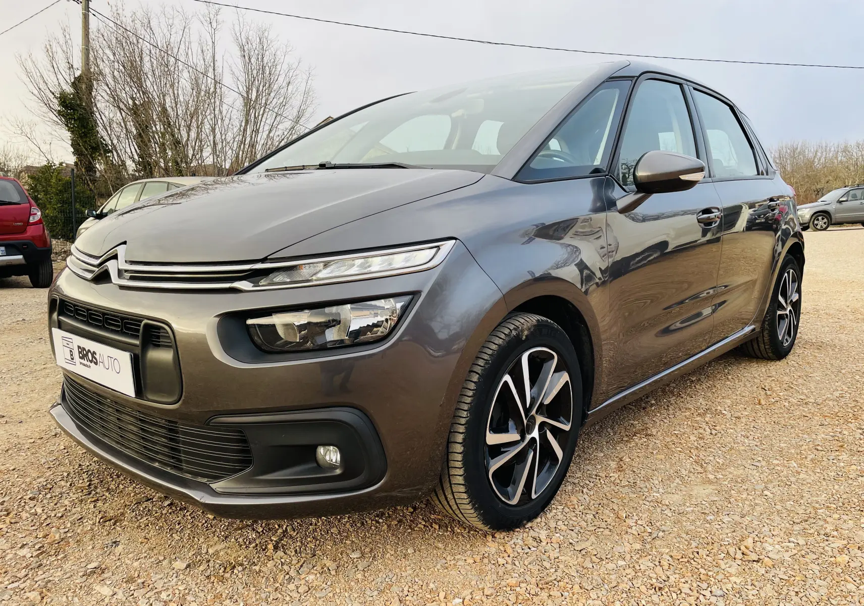 Citroën C4 Picasso gris métal vue 3/4 avant droit, avec phares LED et jantes alliage noires et argentées.