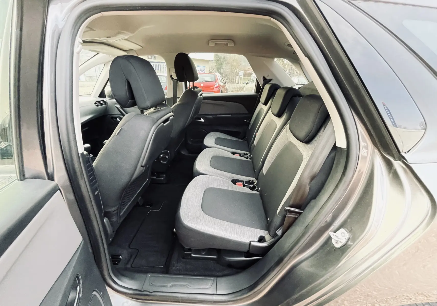 Vue intérieure côté droit des sièges arrière en tissu noir et gris du Citroën C4 Picasso gris 2018.