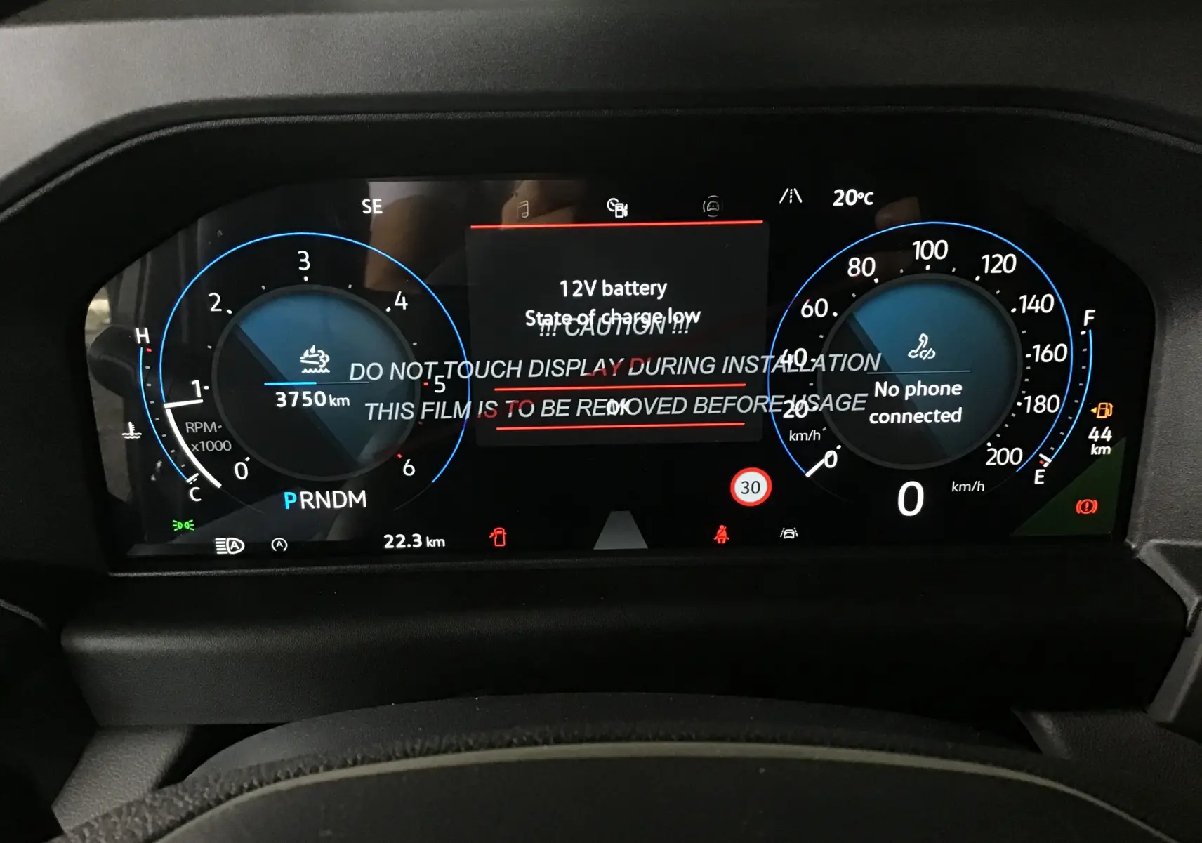 Tableau de bord numérique du Volkswagen Transporter T7 gris anthracite, affichant compte-tours, vitesse et alertes batterie.