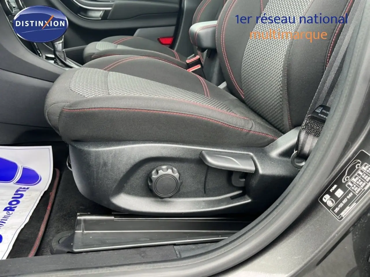 Vue latérale côté gauche du siège avant tissu noir avec surpiqûres rouges du Ford Puma gris Magnetic Metal 2024.