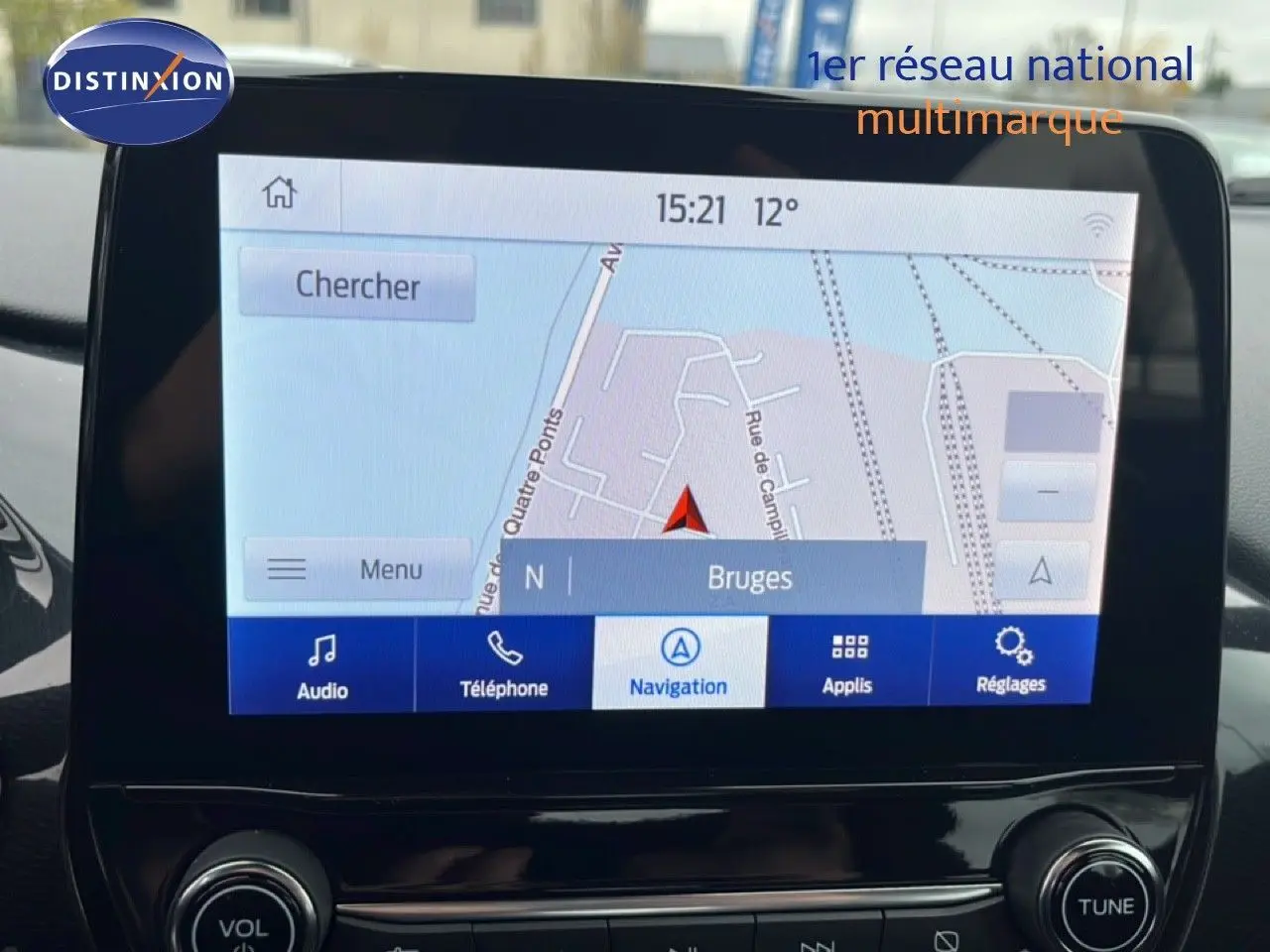 Écran tactile central du Ford Puma 2024 montrant la navigation sur Bruges, avec commandes audio et téléphone visibles.