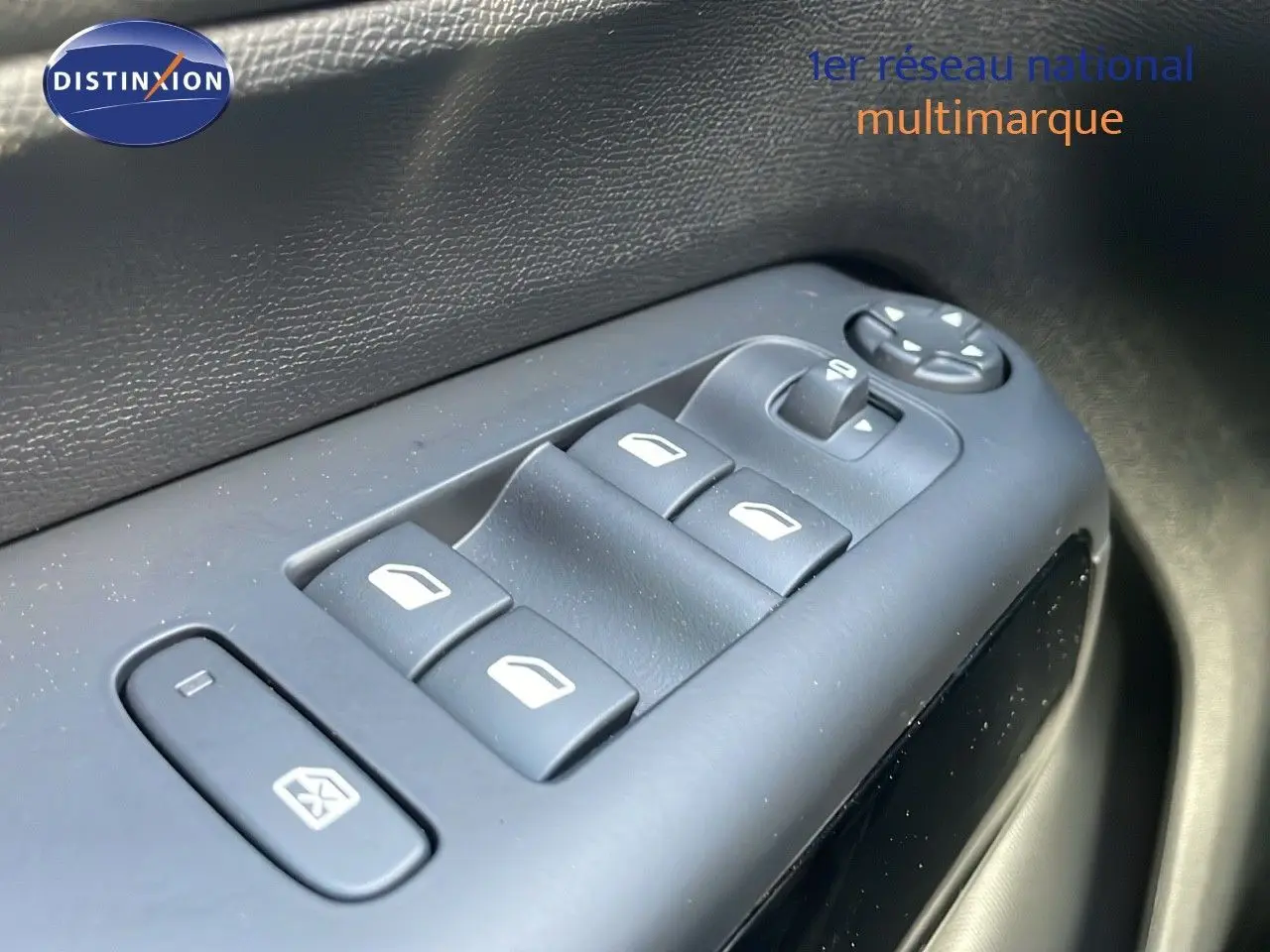 Gros plan sur les commandes des vitres électriques côté gauche d’un Citroën C5 Aircross 2025 bleu Eclipse Metal.