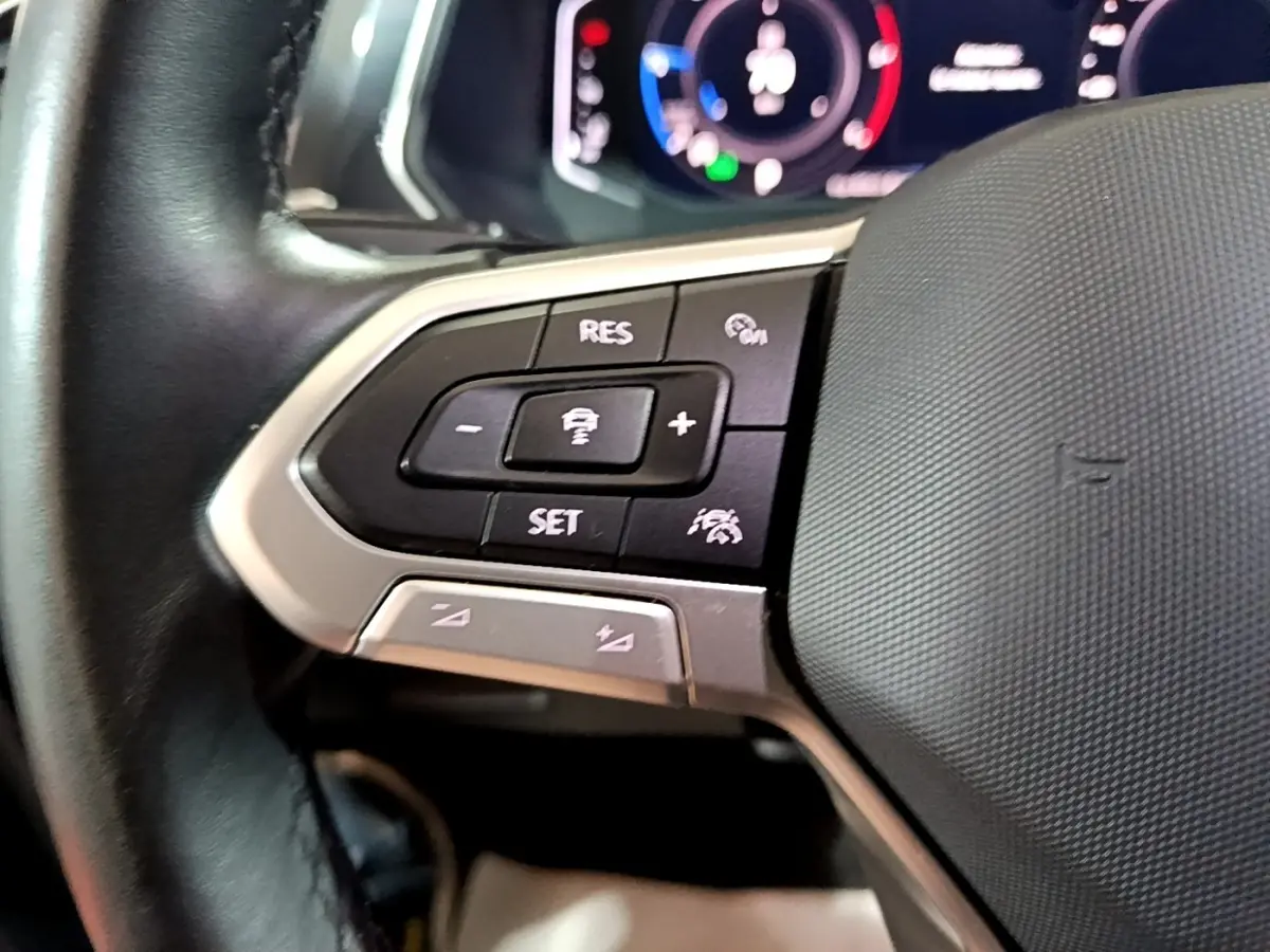 Gros plan sur les commandes de régulateur de vitesse au volant cuir du Volkswagen Tiguan gris foncé 2021.