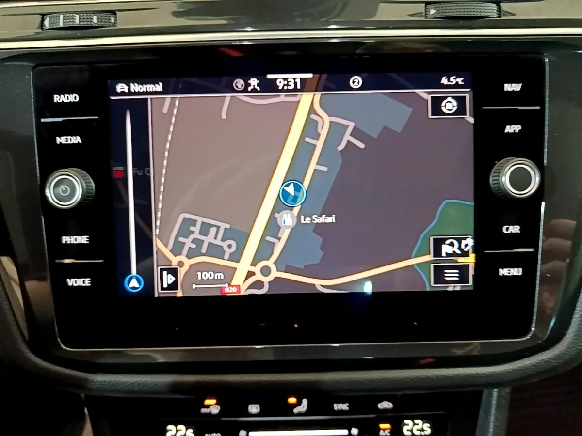 Écran tactile central du Volkswagen Tiguan 2021 affichant la navigation avec carte et commandes autour en noir brillant.