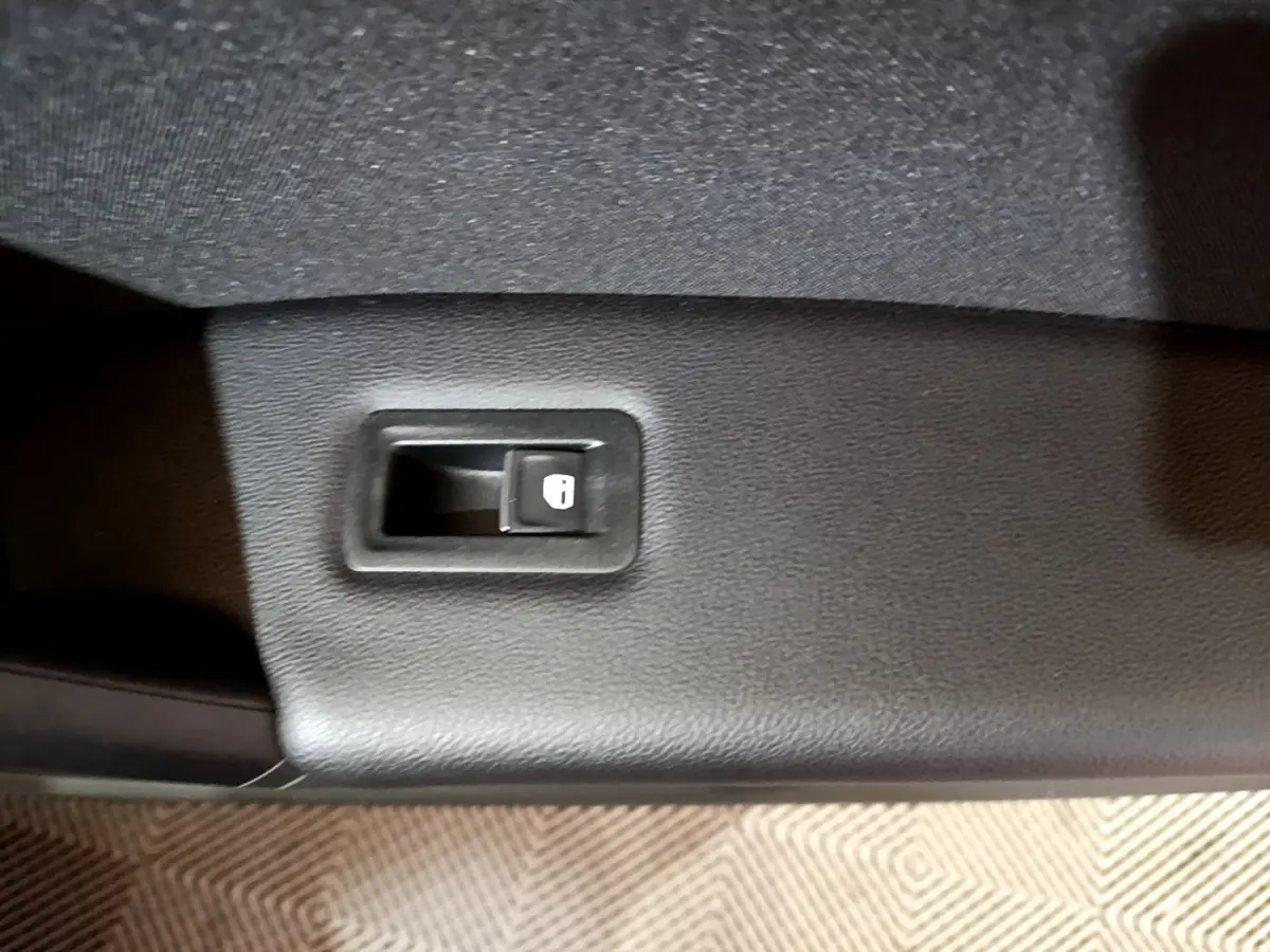 Bouton de verrouillage des portes sur la garniture intérieure noire d'une Volkswagen Tiguan gris foncé 2021.