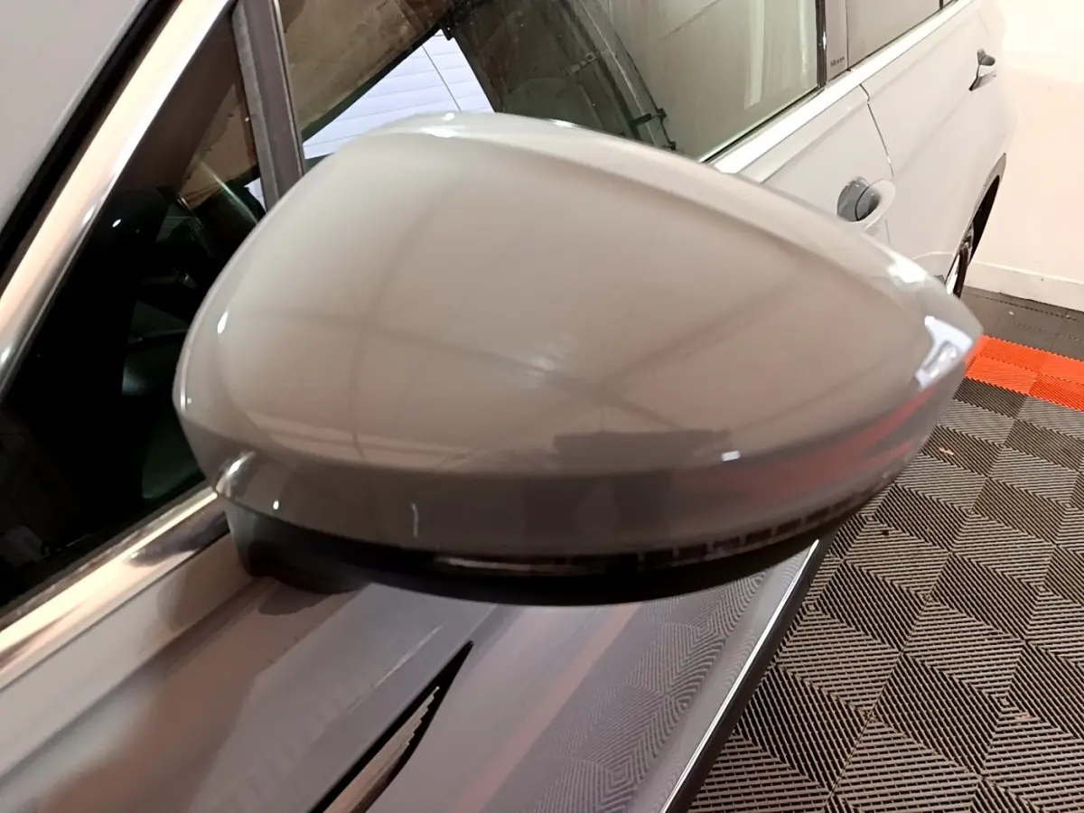 Gros plan sur le rétroviseur droit gris foncé du Volkswagen Tiguan 2021 avec clignotant intégré et carrosserie visible.