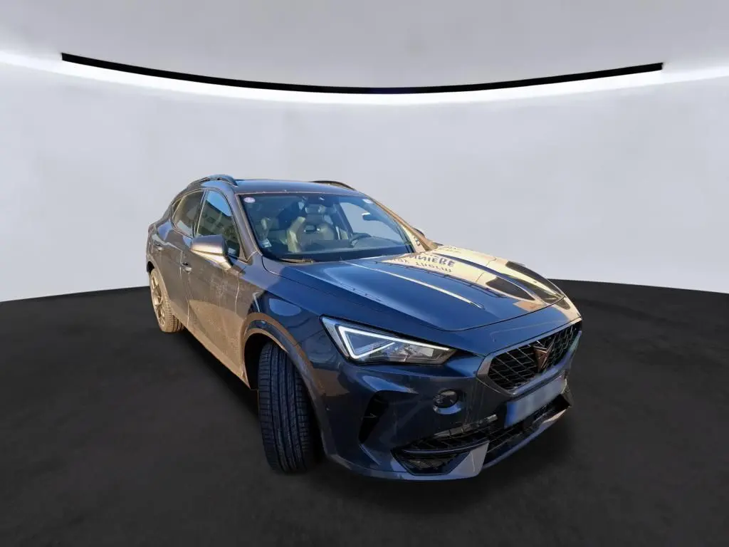 Vue 3/4 avant droite d'un CUPRA Formentor gris foncé 2023 avec calandre distinctive et phares LED anguleux.