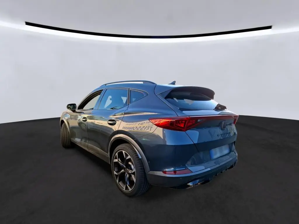 Vue 3/4 arrière droite d'un CUPRA Formentor gris foncé 2023, avec feux arrière allongés et jantes noires sportives.