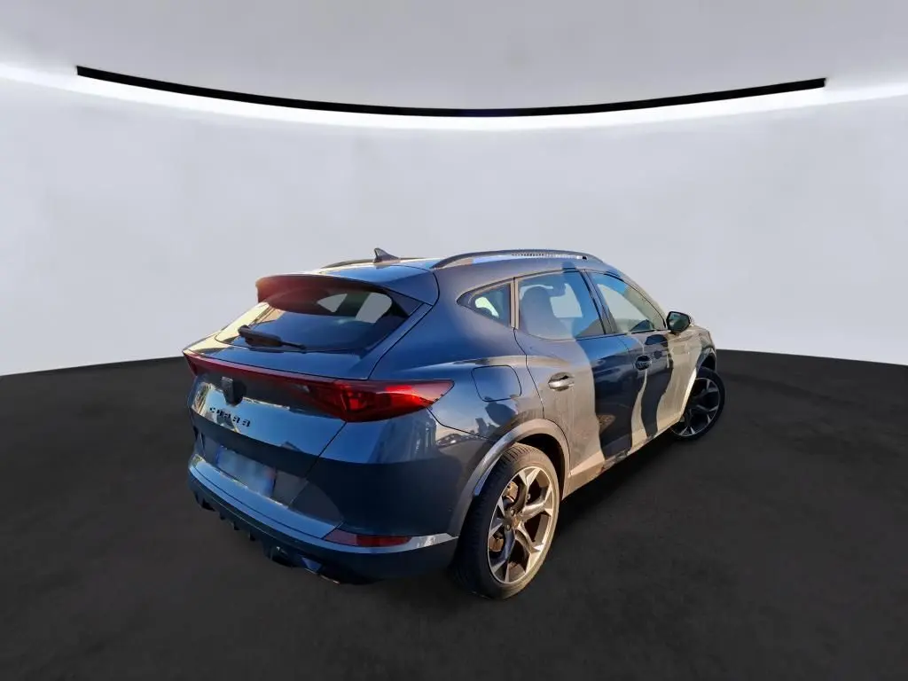 Vue 3/4 arrière droite d'un CUPRA Formentor gris foncé 2023 avec jantes alliage et toit ouvrant.