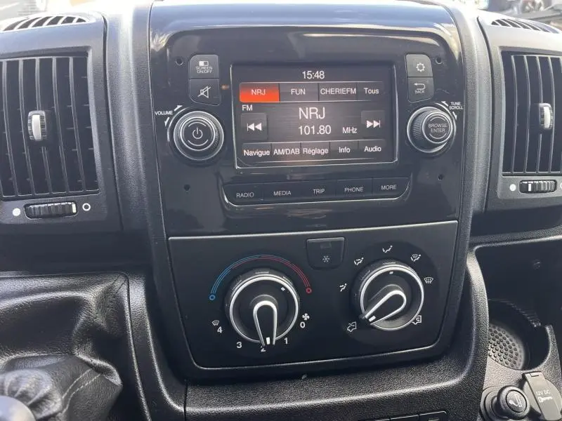 Vue rapprochée du tableau de bord du Citroën Jumper blanc, avec écran tactile et commandes de climatisation visibles.