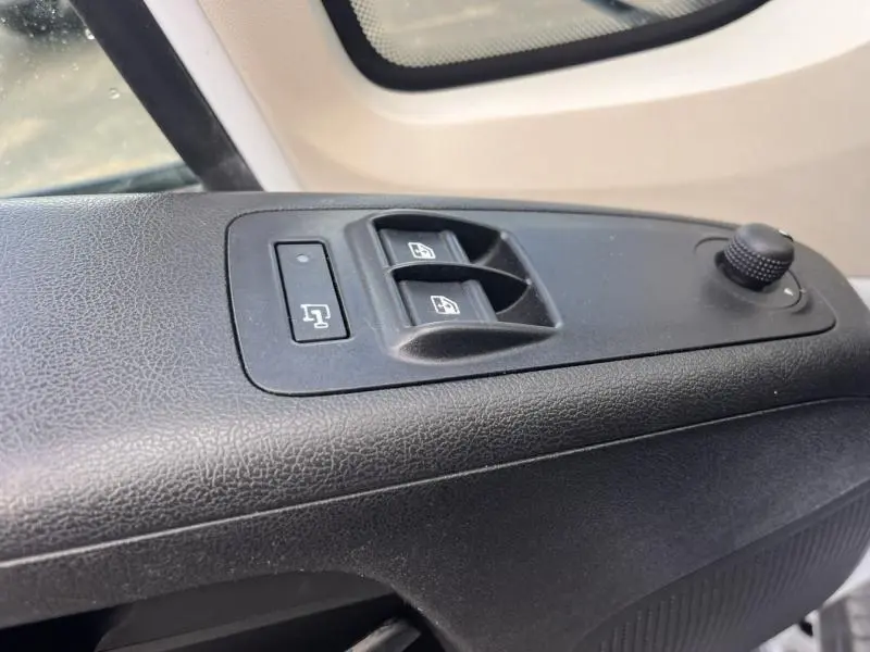 Gros plan sur les commandes des vitres électriques et rétroviseurs côté gauche du Citroën Jumper FGN blanc Icy 2021.