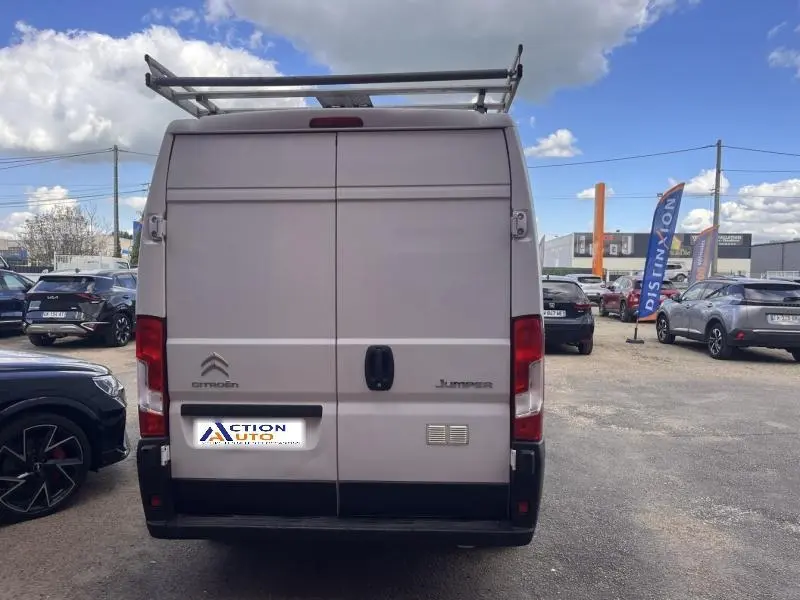 Vue arrière d'un Citroën Jumper blanc Icy avec portes battantes et galerie de toit métallique.