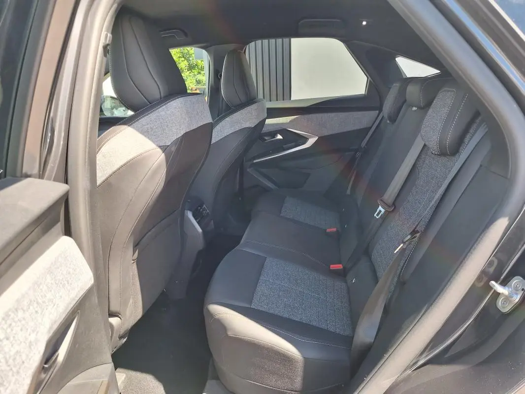 Vue intérieure côté droit des sièges arrière gris foncé mêlant tissu et cuir dans un Peugeot 3008 Hybrid 2025.