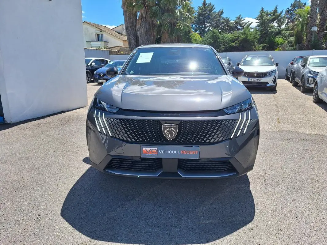 Vue frontale d'un Peugeot 3008 Hybrid gris foncé avec calandre noire et feux LED verticaux distinctifs.