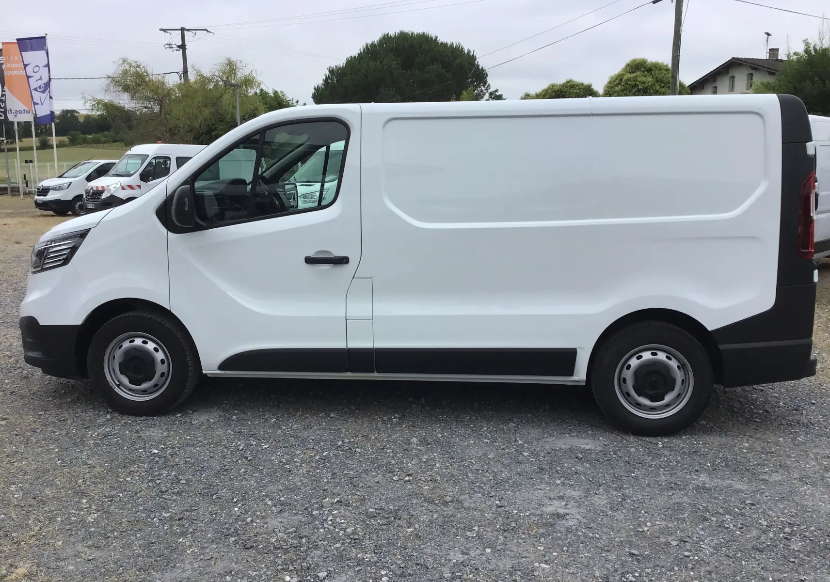 Vue de profil côté gauche d’un Renault Trafic Fourgon blanc 2024 avec portes latérales pleines et jantes acier noires.