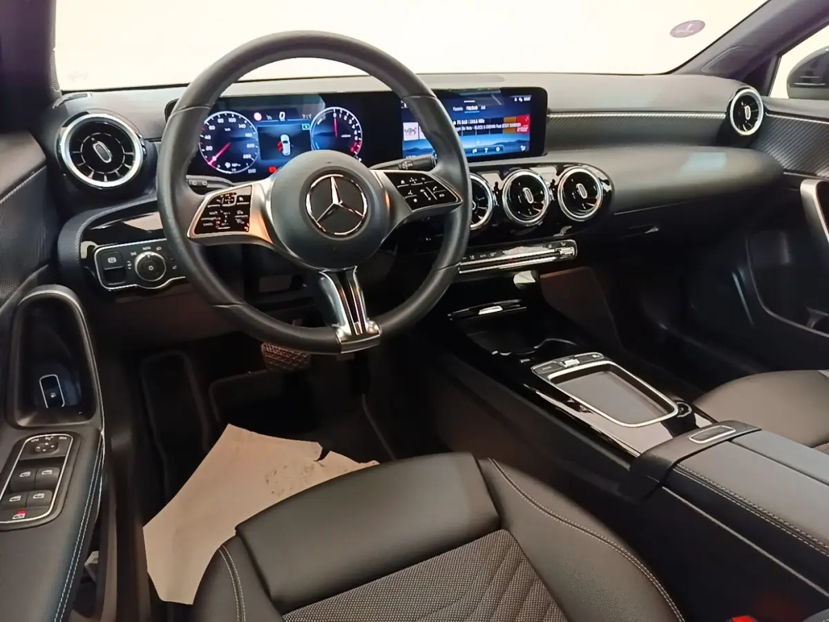 Vue intérieure de face du tableau de bord noir de la Mercedes Classe A 250 e avec écran tactile et volant multifonctions.