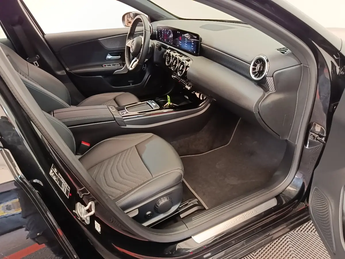 Intérieur noir de la Mercedes Classe A 250 e Business Line 2023 vu côté conducteur, tableau de bord et sièges en cuir.