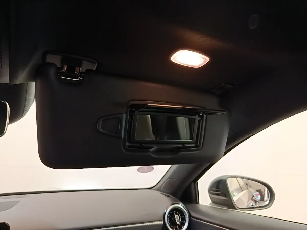 Intérieur de la Mercedes Classe A 250 e Business Line 2023, vue du pare-soleil avec miroir éclairé côté passager.
