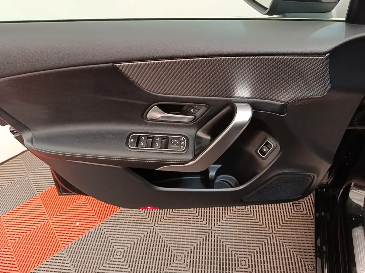Porte côté conducteur de Mercedes Classe A 250 e Business Line 2023 noire, avec insert carbone et commandes électriques.