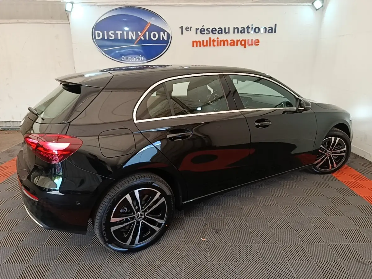 Vue 3/4 arrière droite d'une Mercedes Classe A 250 e Business Line noire avec jantes alliage et feux LED allumés.