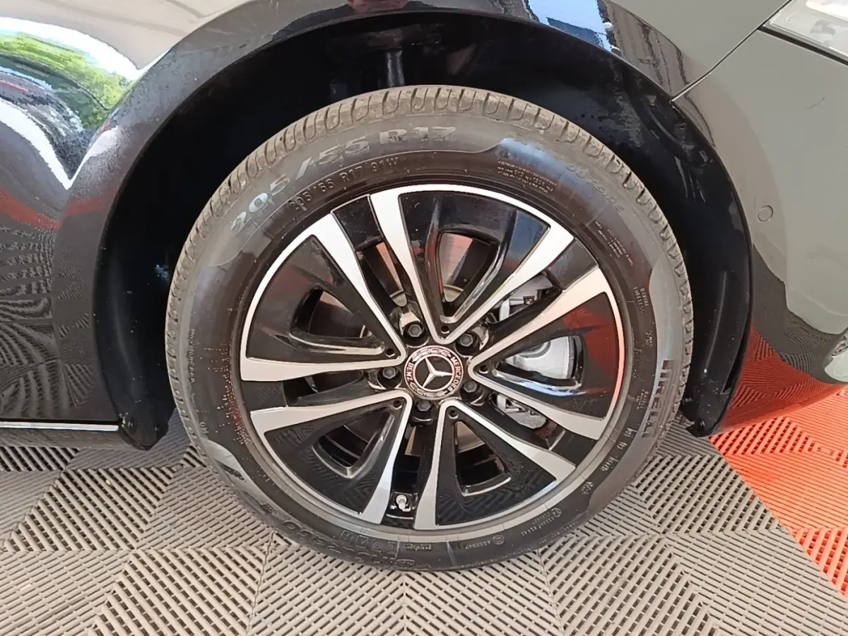 Gros plan sur la roue avant droite noire d'une Mercedes Classe A 250 e Business Line 2023 avec jante alliage bicolore.