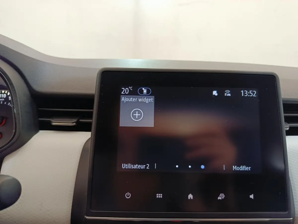 Écran tactile central de 7 pouces de la Renault Clio blanche, affichant le menu principal avec options widget.