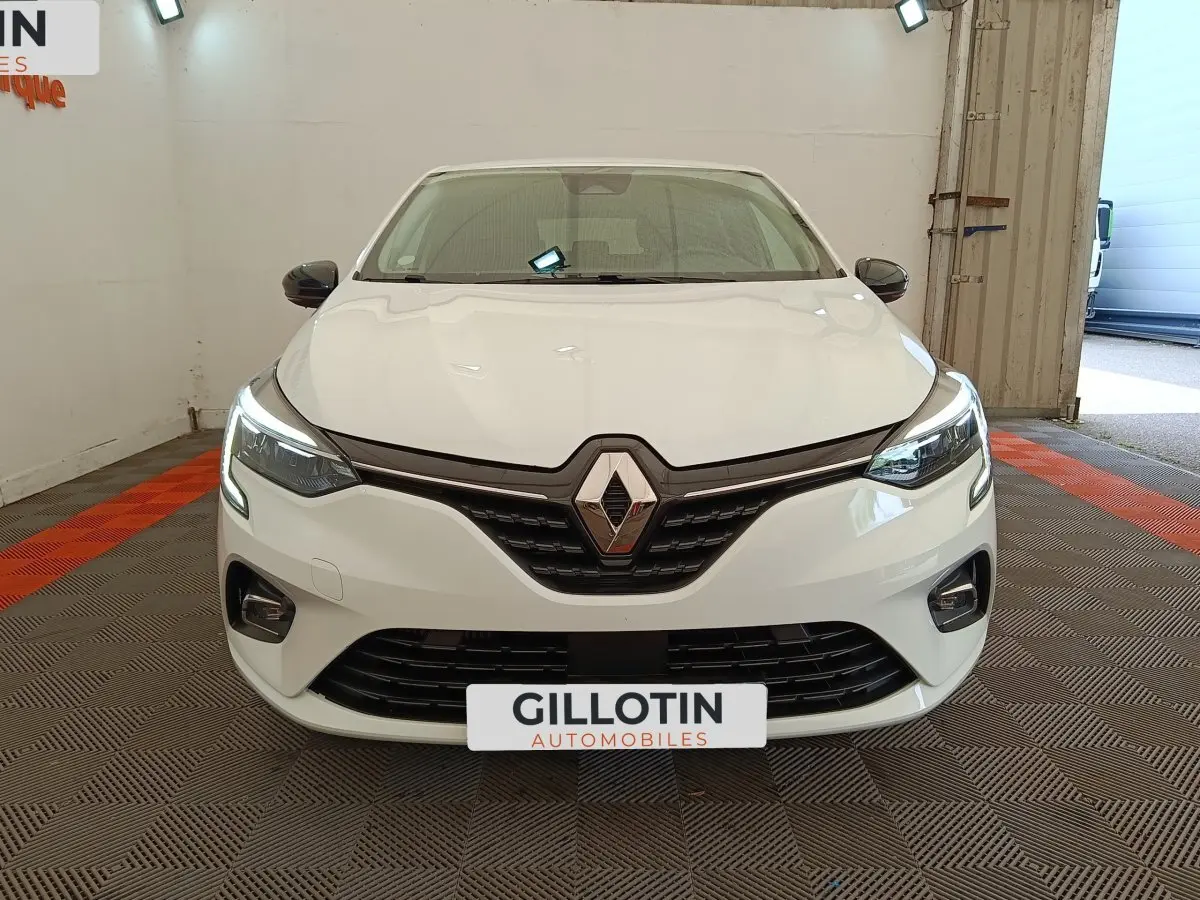 Renault Clio Evolution TCe 100 GPL blanche vue de face, avec feux LED allumés et calandre noire brillante.