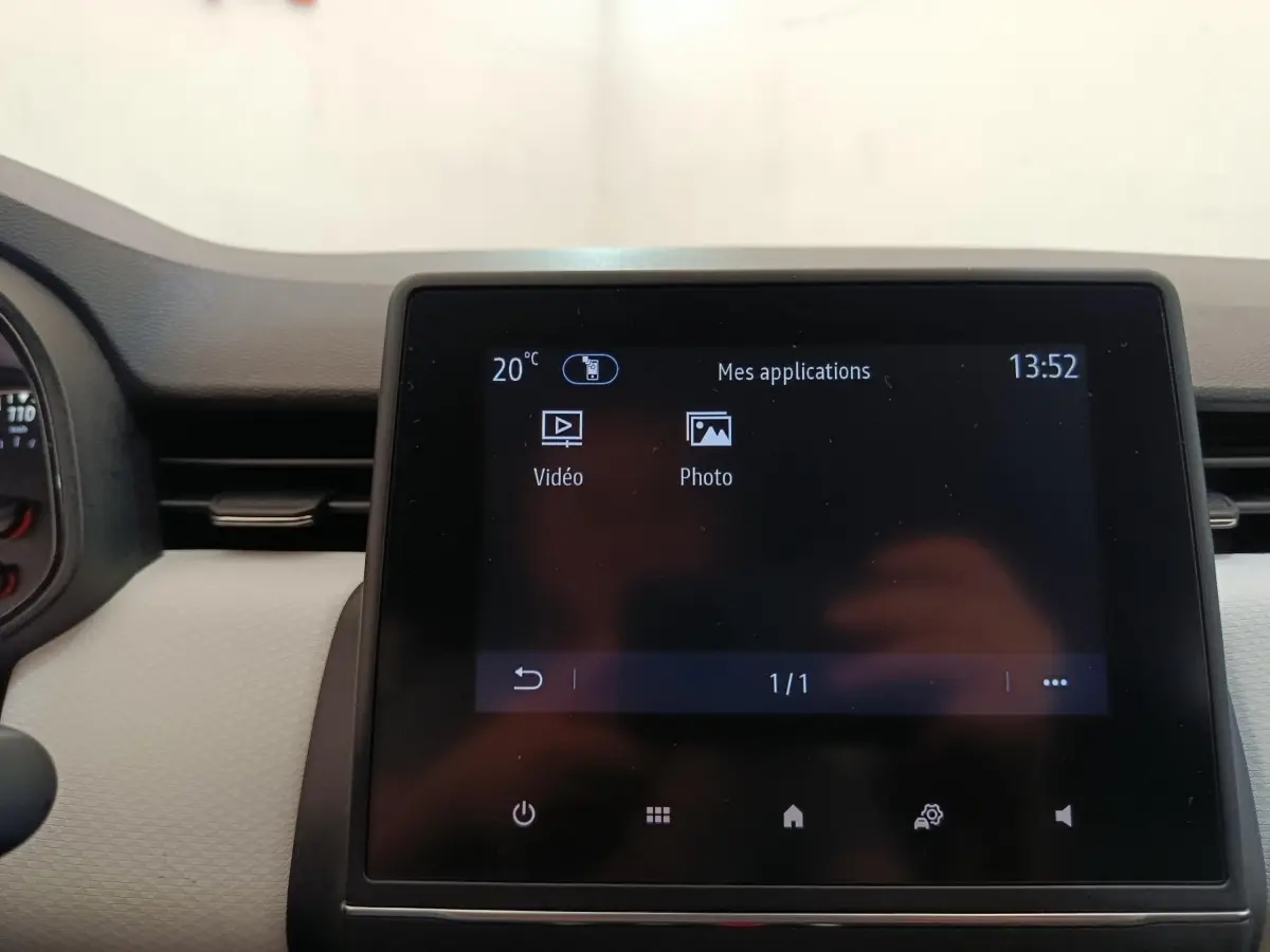 Écran tactile central de la Renault Clio blanc 2023 affichant les applications vidéo et photo.