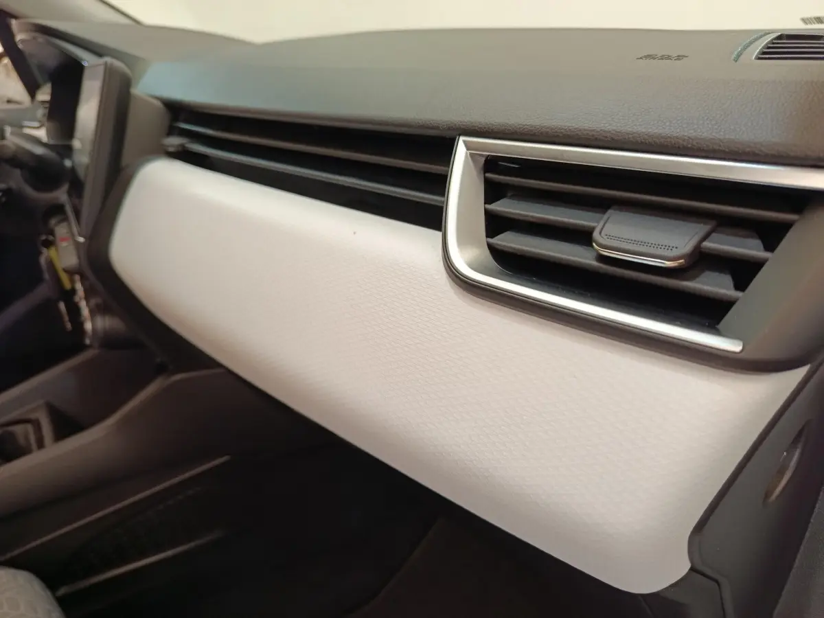 Détail intérieur du tableau de bord blanc et noir de la Renault Clio Evolution TCe 100 GPL 2023, côté passager.