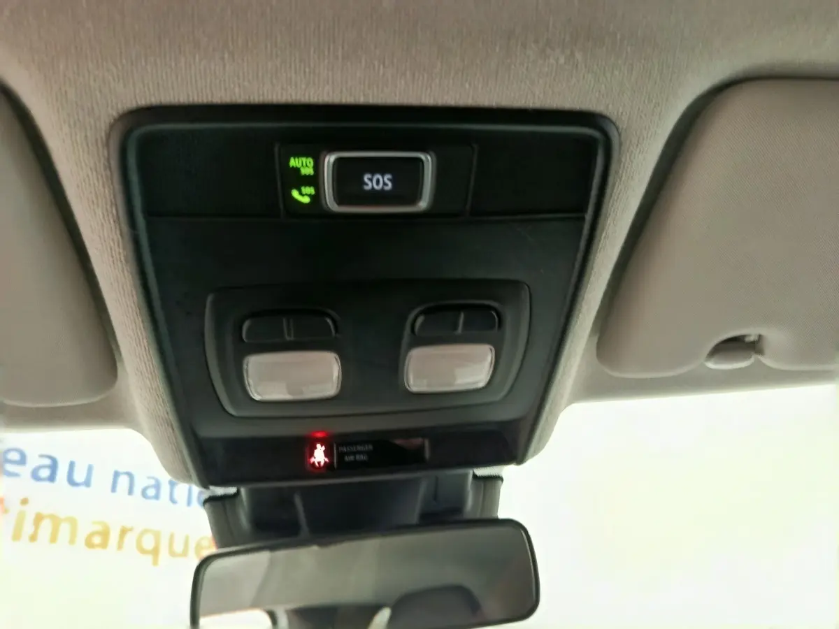 Vue intérieure du plafond avant de la Renault Clio blanc, avec bouton SOS et éclairages de lecture intégrés.