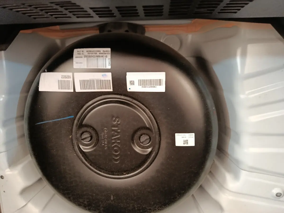 Vue rapprochée du réservoir GPL noir dans le coffre blanc d’une Renault Clio Evolution TCe 100 GPL 2023.