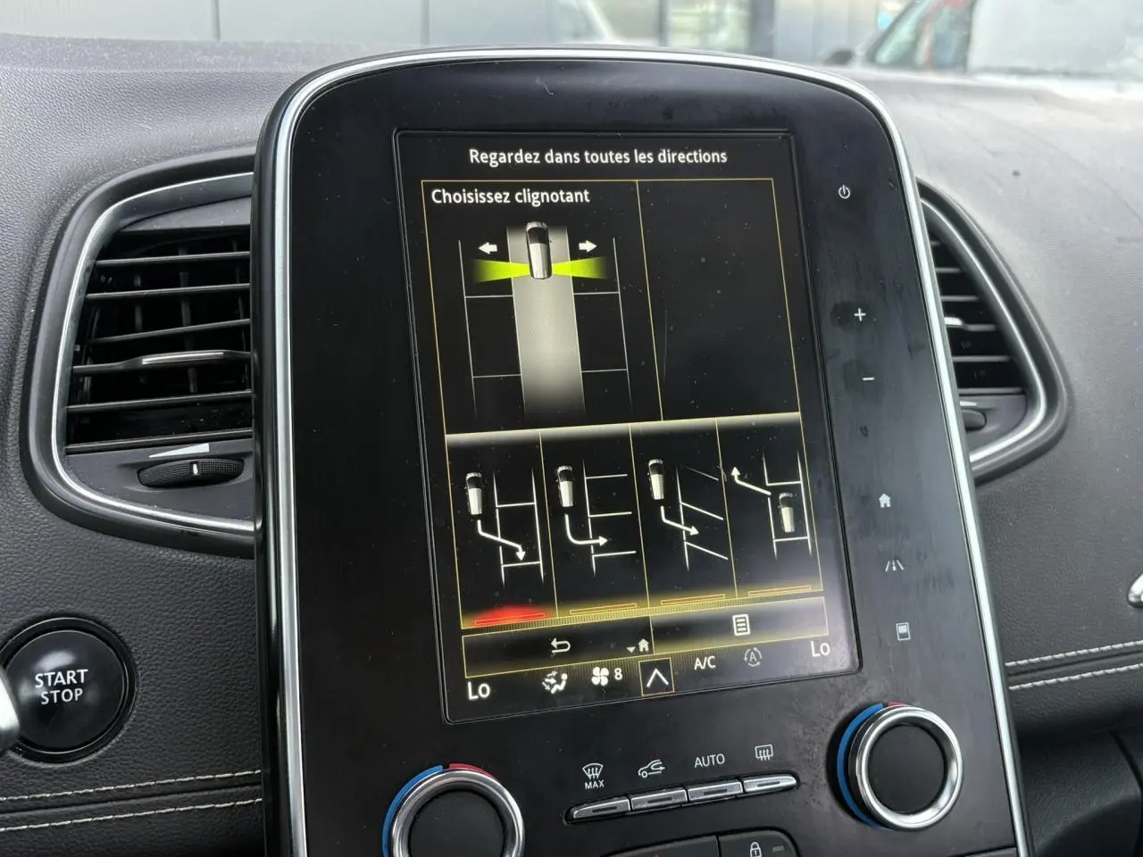 Vue rapprochée de l’écran tactile central du Renault Grand Scénic IV avec commandes de climatisation et bouton Start/Stop.